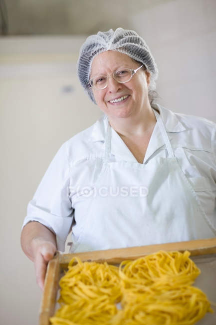 Шеф-кухар тримає лоток макаронів — стокове фото