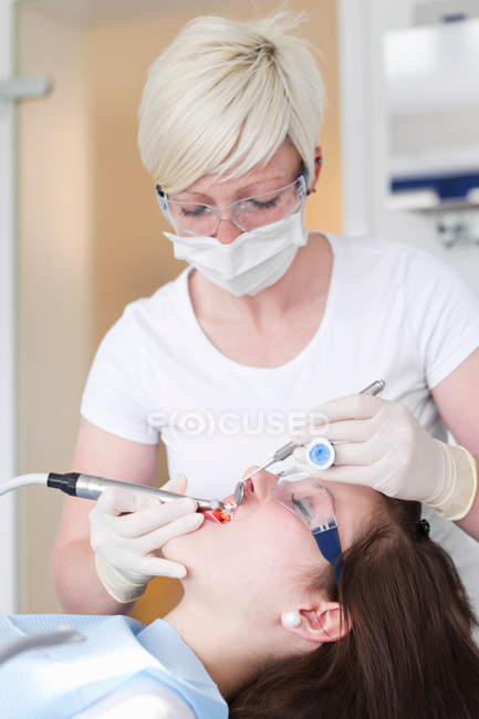 Dentist working on patients teeth — Stock Photo