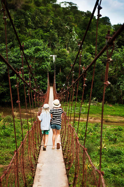 Двое детей идут по веревочному мосту — стоковое фото