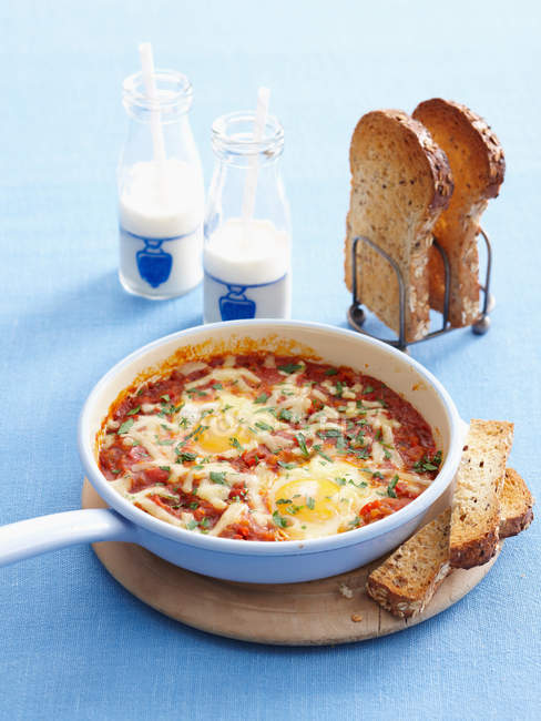 Pan of eggs cooked in sauce — Stock Photo