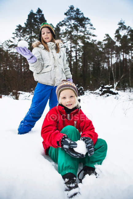 Bambini che fanno palle di neve nella neve — Foto stock