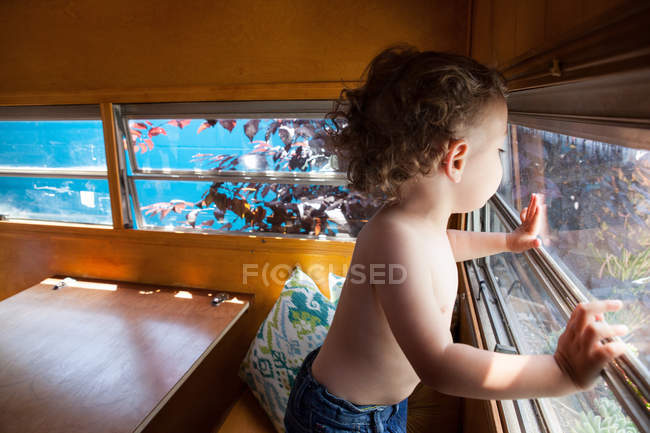 Мальчик стоит у окна — стоковое фото