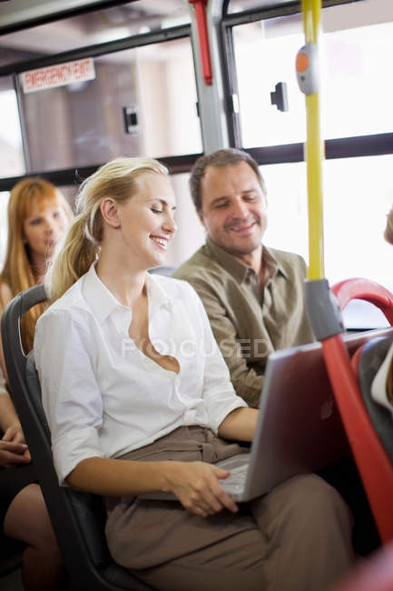 Personas sonrientes sentadas en el autobús - foto de stock