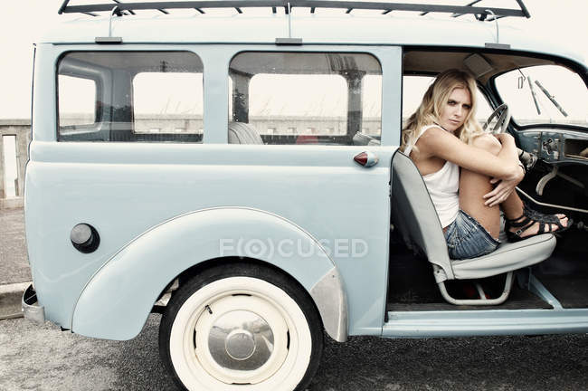 Femme étreignant ses genoux dans la voiture — Photo de stock