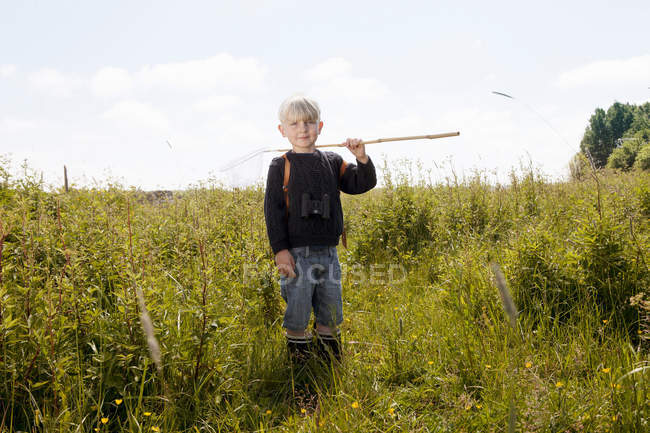 Хлопчик стоїть на полі високої трави — стокове фото