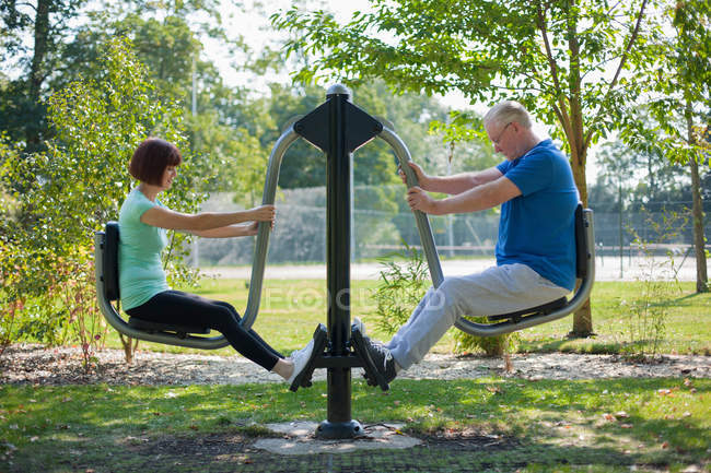 Older couple using exercise equipment — Stock Photo