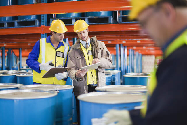 Workers reading clipboards in warehouse — Stock Photo