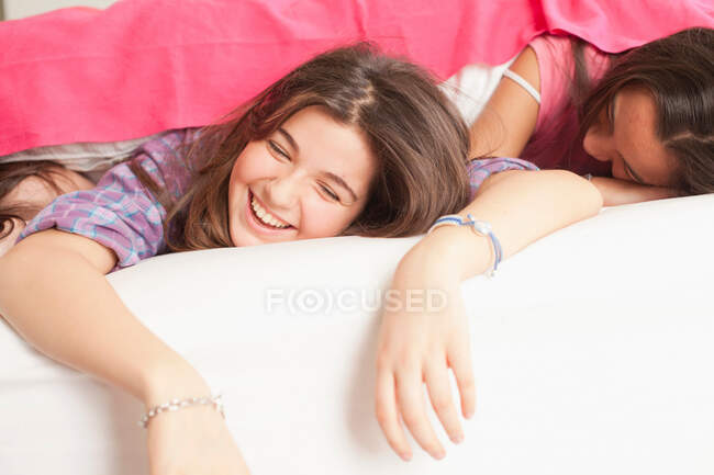 Mädchen liegen lachend im Bett — Stockfoto