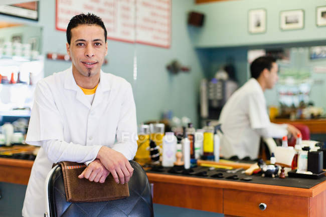 Barber standing at chair in shop — Stock Photo