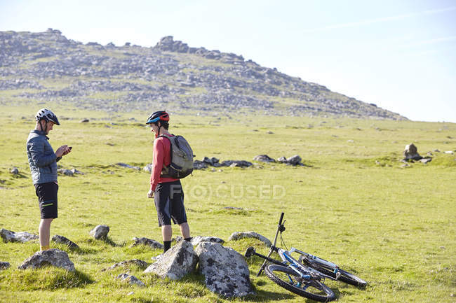 Cyclists on hillside chatting — Stock Photo
