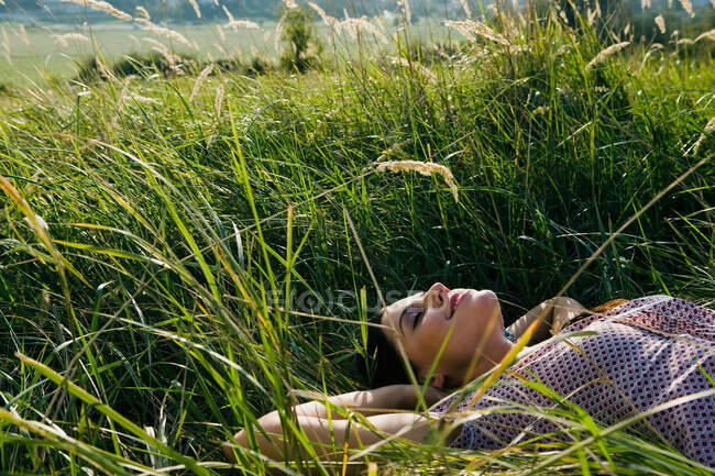 Jovem mulher deitada na grama — Fotografia de Stock