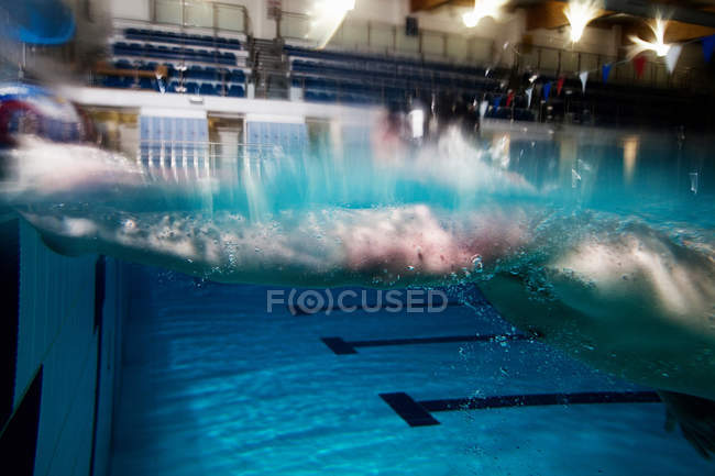 Movimento turvo do atleta masculino nadando na piscina — Fotografia de Stock