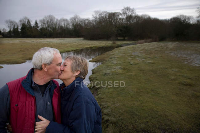 Couple retraité s'embrassant à l'extérieur — Photo de stock
