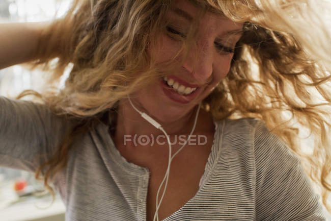 Woman dancing with earphones at home — Stock Photo