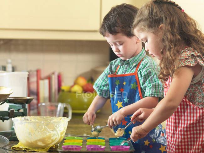 Crianças assando juntos na cozinha — Fotografia de Stock