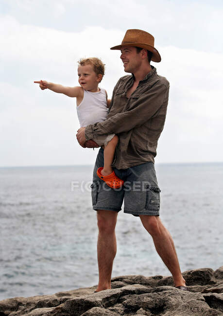 Отец и сын с видом на океан — стоковое фото