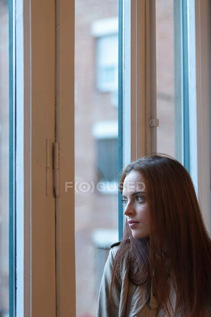 Mulher pela janela — Fotografia de Stock