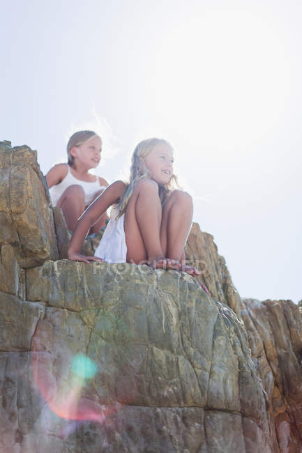 Девушки сидят на камнях на открытом воздухе — стоковое фото