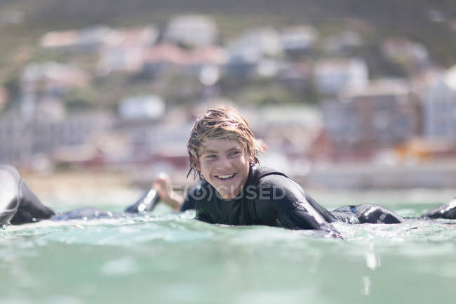 Rapaz adolescente remando com prancha de surf, foco seletivo — Fotografia de Stock
