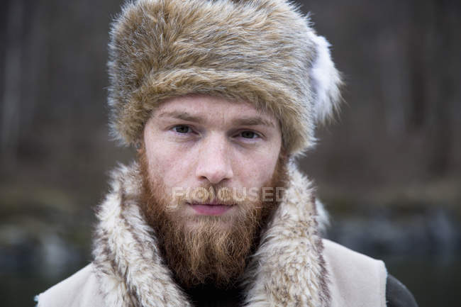 Homme adulte moyen portant un chapeau de trappeur, portrait — Photo de stock