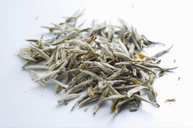 Tea leaves pile on white — Stock Photo