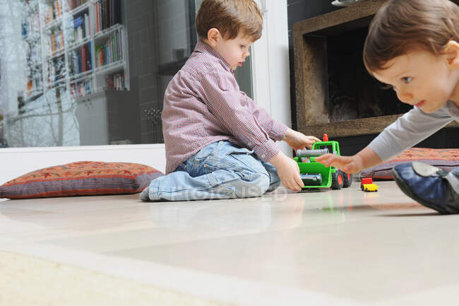 Мальчик играет с игрушечными машинами — стоковое фото