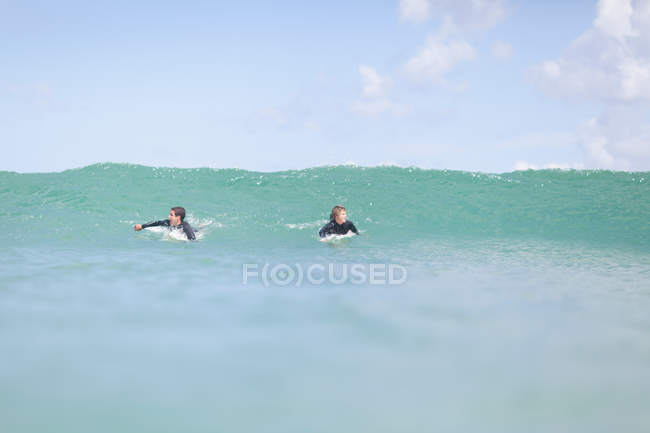 Teenager paddeln mit Surfbrett — Stockfoto