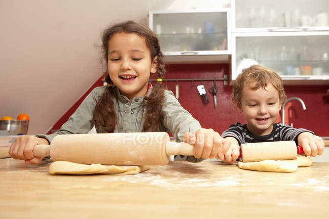 Дети вместе пекут на кухне — стоковое фото