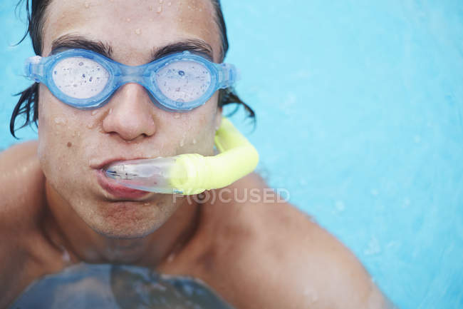 Portrait de jeune homme portant des lunettes de plongée dans la piscine — Photo de stock