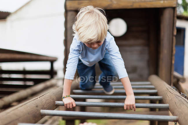 Boy playing on monkey bars, selective focus — Stock Photo