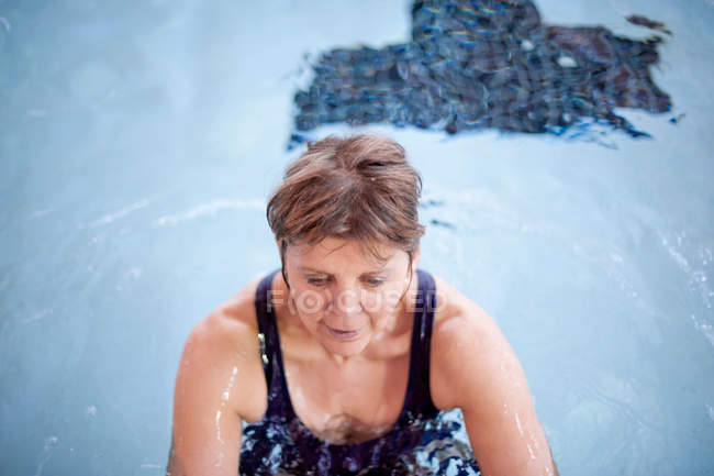 Mujer salpicando en la piscina - foto de stock