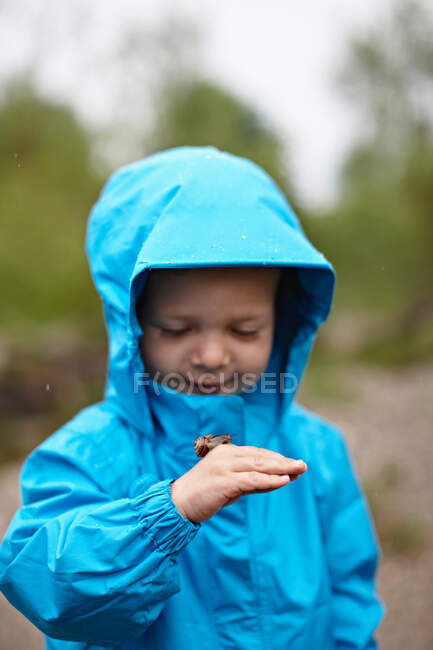 Toddler boy playing with insect outdoors — Stock Photo
