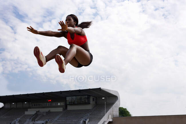 Atleta a mezz'aria durante il salto in lungo — Foto stock