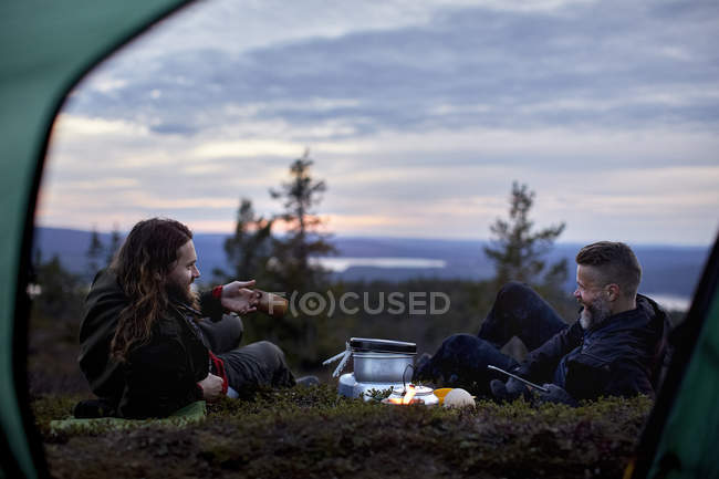 Escursionisti che si rilassano, chattando davanti alla tenda, Keimiotunturi, Lapponia, Finlandia — Foto stock