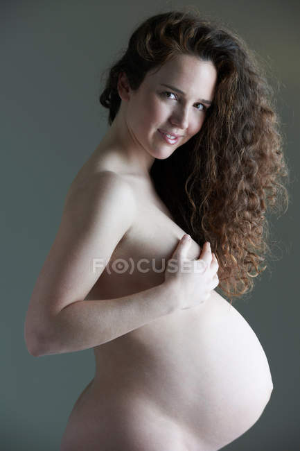 Улыбающаяся обнаженная беременная женщина — стоковое фото