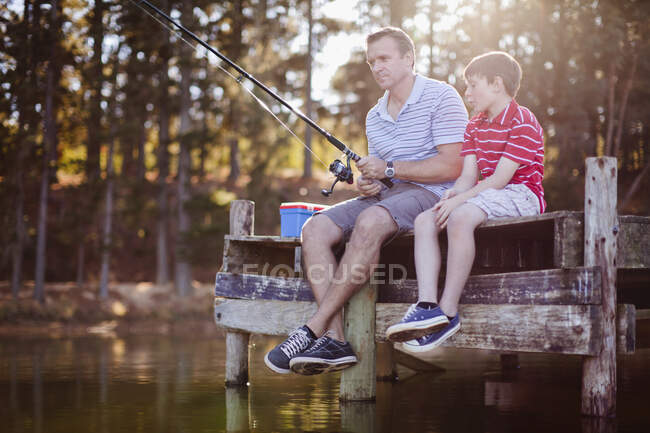 Padre pescando con hijo en el lago - foto de stock