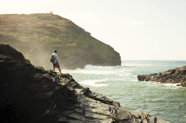 Man gazing out from rocky cliffs, Boscastle, Cornwall, Reino Unido — Fotografia de Stock