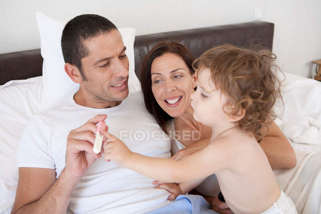 Family playing in bed together — Stock Photo