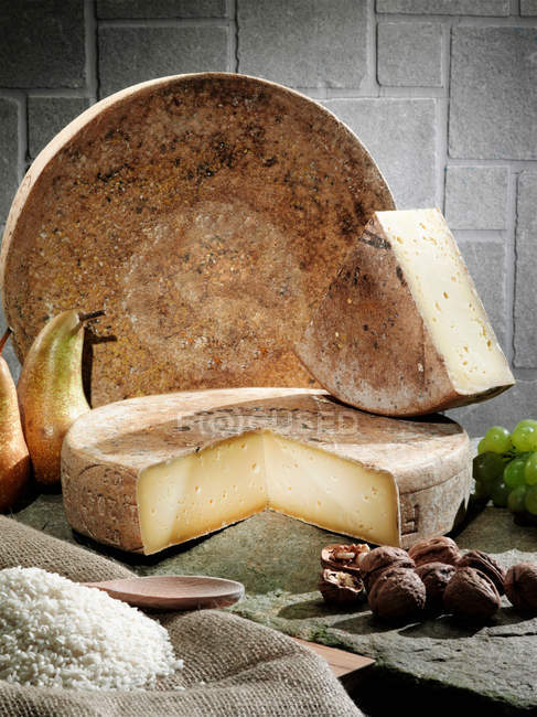 Cheese with fruits and grains on table — Stock Photo