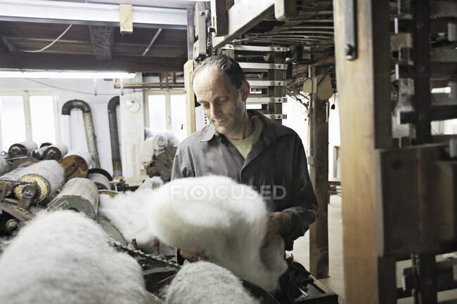 Worker looking at fleece in wool factory — Stock Photo