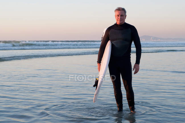 Surfista parado en el agua - foto de stock