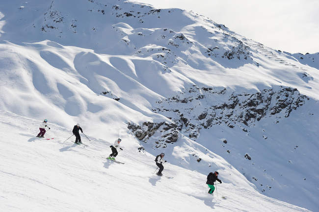 Esquiadores esquiando juntos na encosta — Fotografia de Stock