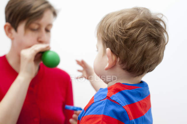 Mother blowing balloon for son — Stock Photo