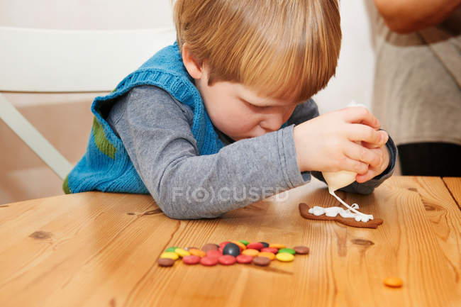 Хлопчик прикрашає імбирне печиво — стокове фото