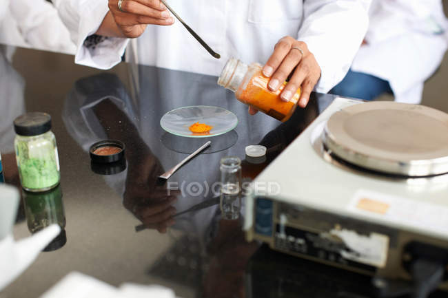 Técnico que pesa productos químicos en laboratorio - foto de stock