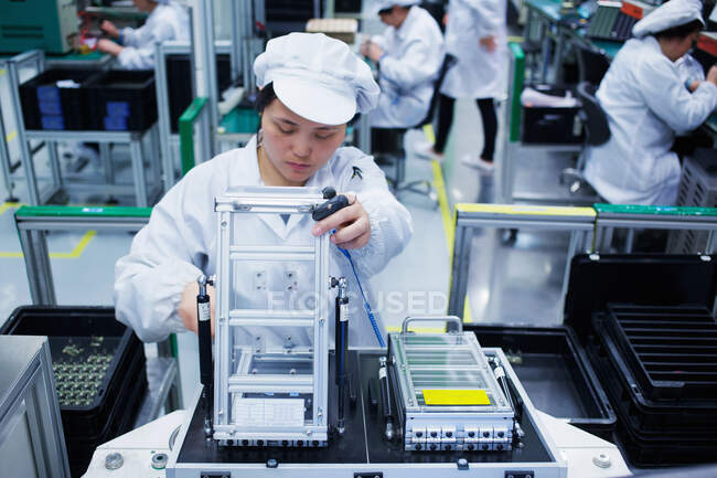 Travailleur dans une usine de fabrication de petites pièces en Chine — Photo de stock