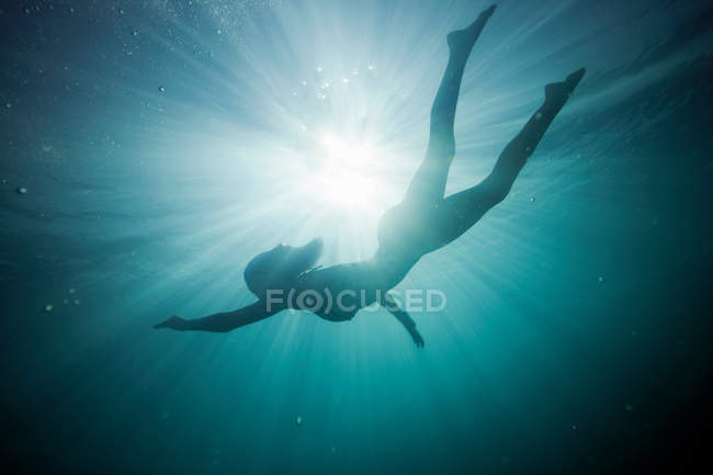Silhouette eines Mädchens unter Wasser — Stockfoto