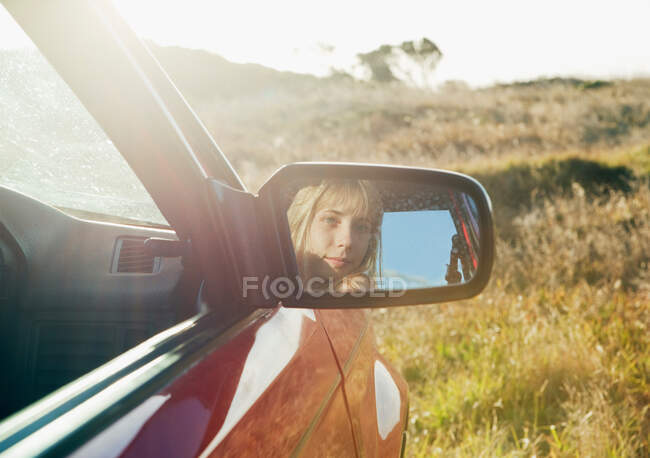 Menina olhando no espelho do carro — Fotografia de Stock