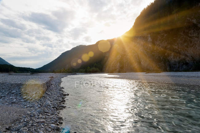 Puesta de sol sobre el río rocoso - foto de stock