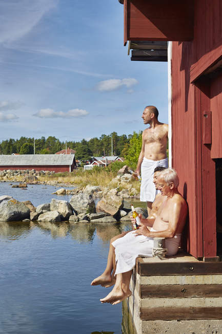 Trois amis masculins reposant à l'extérieur du sauna — Photo de stock
